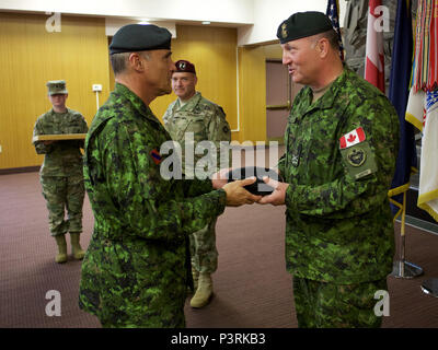 Canadian Army Brig. Gen. Martin Frank (right), U.S. Army Alaska deputy commander - operations, receives a beret with his new rank insignia from Canadian Army Maj. Gen. J.C.G. Juneau, Canadian Army deputy commander, during the newly minted brigadier general's July 22 promotion at Joint Base Elmendorf-Richardson. Martin will soon take an assignment in Canada. (U.S. Air Force photo by David Bedard) Stock Photo