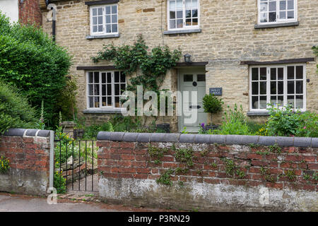 Frontage and walled front garden of a stone built house in the village of Nether Heyford, Northamptonshire, UK Stock Photo