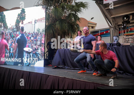 Celebrity Chef Robert Irvine and Lance Cpl. Kai Wendland, a combat engineer with Special Purpose Marine Air-Ground Task Force Crisis Response-Africa, bust some moves on stage during a show at Naval Air Station Sigonella, Italy, July 28, 2016.  Marines attended the show and participated in the cooking challenges throughout the night.  (U.S. Marine Corps photo by Cpl. Alexander Mitchell/released) Stock Photo