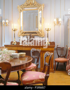 Large antique gilt mirror above marble fireplace in cream country Stock ...