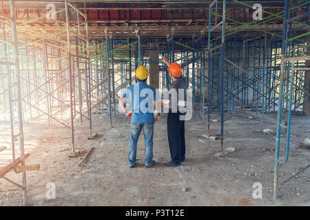 Engineer discussing with foreman about project in building construction site Stock Photo