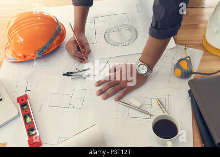 Architect or engineer using pencil working on blueprint, architectural concept Stock Photo