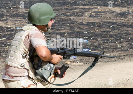 A Peshmerga soldier loads a magazine into his M16 rifle during the modern brigade course 2 final exercise at a training site near Atrush, Iraq, July 26, 2016. The MBC 2 final exercise tested the training and skills of the Peshmerga through practical scenarios that combined platoon-based movements and assaults with mortar and sniper support. This training is provided by Coalition trainers in support of Combined Joint Task Force – Operation Inherent Resolve multinational effort to increase the security capacity of local forces fighting Da’esh.  (U.S. Army Photo by Staff Sgt. Peter J. Berardi) Stock Photo