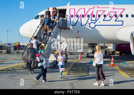 COPENHAGEN, DENMARK - JUN 13, 2018: People leave an airplane at an airport. Copenhagenis the capital and most populous city of Denmark. Stock Photo