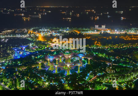 SINGAPORE - MARCH 07 : An aerial view of Gardens by the Bay and industrial ships in  Singapore port. Gardens by the Bay is a park spanning 101 hectare Stock Photo