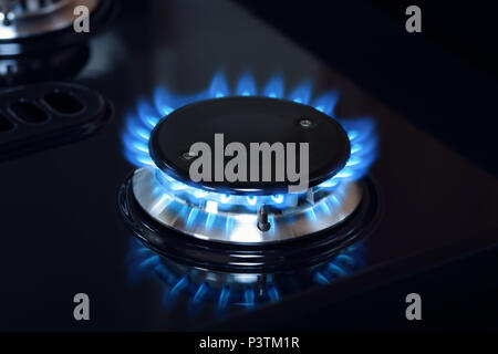 Natural gas burner flame on black stove Stock Photo