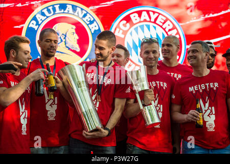 A fan of FC Bayern Munich holds a championship shield ...