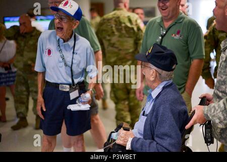 Raleigh, North Carolina – WWII Veterans who served with the 30th Infantry Division, Peter Munger, left and Hank Stairs, seated, laugh with each other in the lobby of the North Carolina National Guard’s Joint Force Headquarters in Raleigh, North Carolina on July 29, 2016 while visiting as part of the 30th Infantry Division Association’s 70th Reunion. The association is behond a push to get the 30th recognized with the Presidential Unti Citation for their actions in WWII where Army Historian, S.L.A. Marshall, named them the most outstanding Infantry Division in the European Theater of Operations Stock Photo