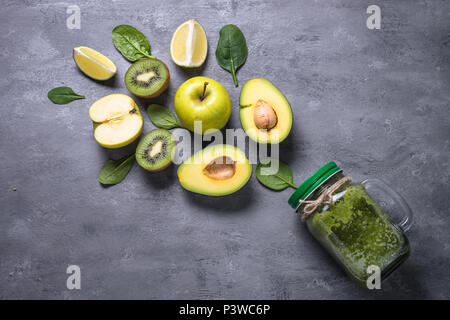 Green smoothie in mason jar and ingredients. Superfoods, detox, diet, healthy food. Lime, apple, spinach avocado and lime Stock Photo