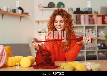 Cheerful red-haired girl feeling satisfied enjoying her hobby Stock Photo