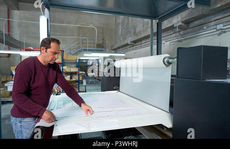 Calender transfer machine production operator man for textile fashion printing industry factory Stock Photo