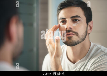 Young Man Applying Anti-aging Lotion fot Skin Care Stock Photo