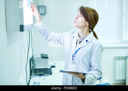 Doctor standing and looking at X-ray  Stock Photo