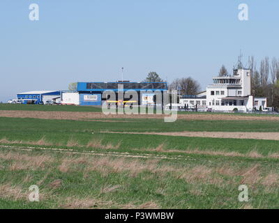 BIELSKO-BIALA, POLAND on APRIL 2018: Local sport airport, hangar and control tower at grassy airfield belongs to air club in european city landscapes  Stock Photo