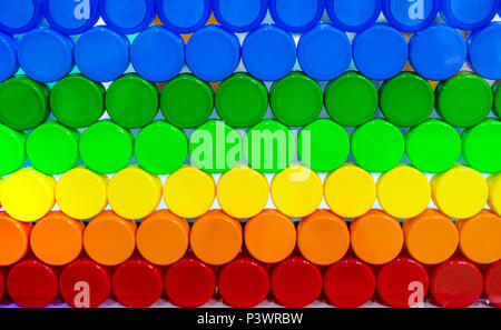 Colorful plastic bottle cap arrange with beautiful tone and pattern. Blue, green, yellow, orange, and red plastic bottle cap arrange with orderly. Cap Stock Photo