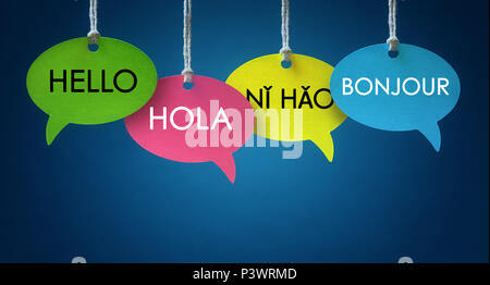 Foreign language colorful communication speech bubbles hanging from a cord over blue background Stock Photo