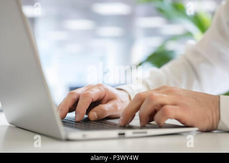 Businessman using laptop computer in office Stock Photo