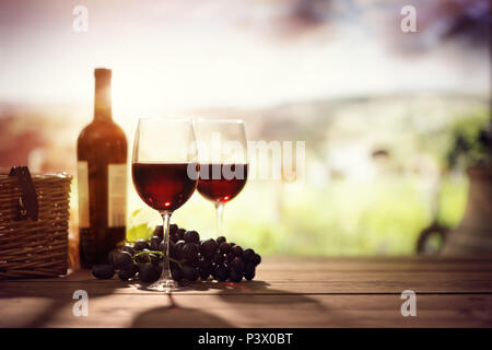 Red wine bottle and glass on table in vineyard Tuscany Italy Stock Photo