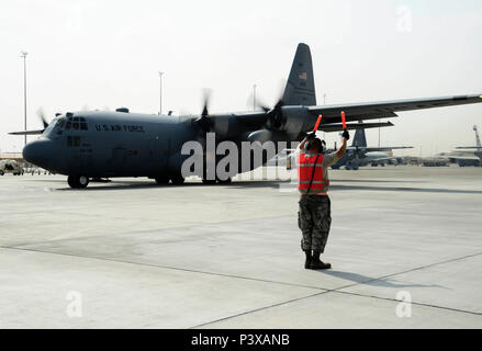 Senior Airman Steven Engels, 379th Expeditionary Aircraft Maintenance Squadron crew chief, marshals a C-130 Hercules on the flight line June 28, 2016, at Al Udeid Air Base, Qatar. Airmen from the 379th EAMXS are responsible for ensuring the aircraft are maintained to exact standards to support Operation Inherent Resolve and Operations Freedom’s Sentinel. (U.S. Air Force photo/Senior Airman Janelle Patiño/Released) Stock Photo