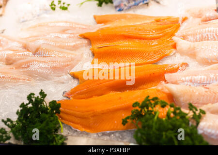 Fresh fish fillets like salmon and cod lay on ice Stock Photo