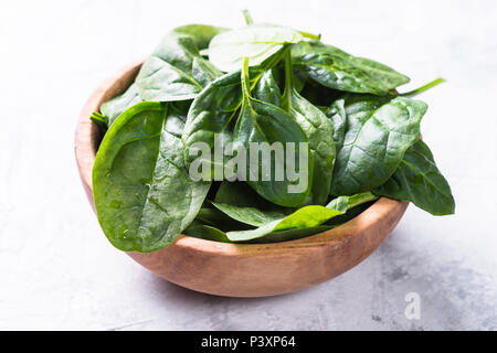 Baby spinach in wooden bowl. Close up. Stock Photo