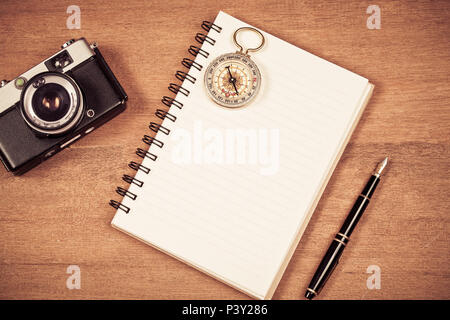 vintage compass on book note and fountain pen on wood table. Stock Photo