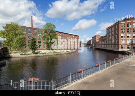 Old red brick industrial buildings along the Tammerkoski rapids in downtown Tampere, Finland on a sunny day. Stock Photo