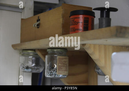 Porta objetos feito de pote de conserva em estante. Stock Photo