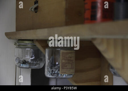 Porta objetos feito de pote de conserva em estante. Stock Photo