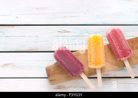 Various flavored ice popsicles over wooden background Stock Photo