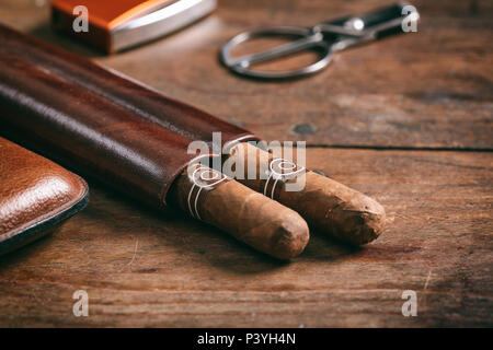 Cuban cigars in a leather case on wooden background, copy space Stock Photo
