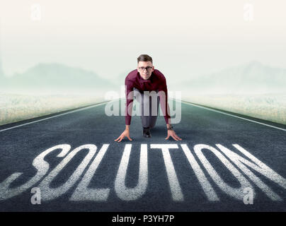 Young determined businessman kneeling before solution text Stock Photo