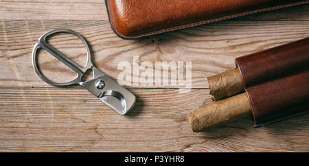 Cuban cigars in a leather case on wooden background, top view Stock Photo