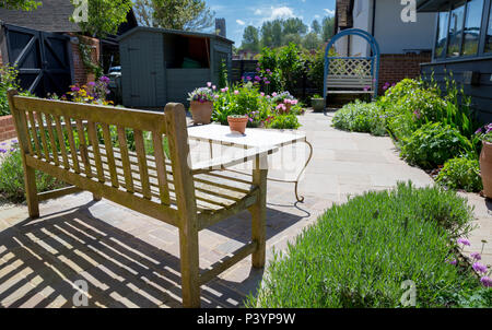 Overview of garden patio featuring two separate seating areas and a log store Stock Photo