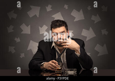 Drunk disappointed man sitting at table with arrows around  Stock Photo