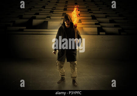 Ugly, aberrant man coming out from the labyrinth with burning flambeau on his hand  Stock Photo