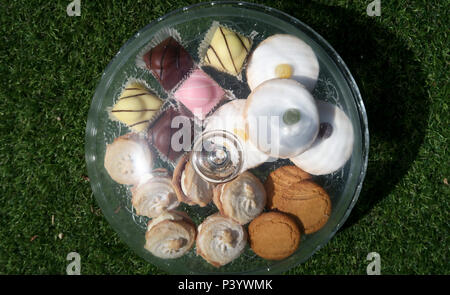 Selection of cakes under glass dome Stock Photo