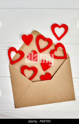 Opened envelope and red paper hearts. Envelope from craft paper and many red hearts. Love letter concept. Stock Photo