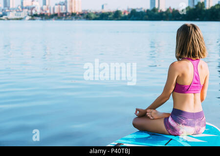 woman doing yoga on sup board Stock Photo