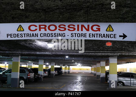 Coquitlam, BC, Canada - May 08, 2018 : Motion of pedestrian crossing and store entrance sign hanging on roof at parking lot Stock Photo