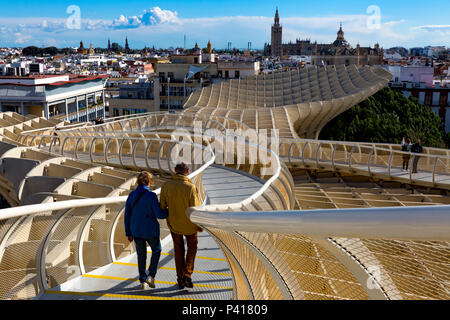 Couple walking The Metropol Parasol overhead walkway, Plaza De La Encarnacion, Seville, Andalusia, Spain.