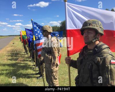 Soldiers representing eight nations display their national colors during an opening ceremony for Exercise Anakonda 2016 at the Drawsko Pomorskie Training Area, Poland, June 6. Exercise Anakonda 2016 is a Polish-led, joint multinational exercise taking place throughout Poland June 7-17. The exercise involves approximately 31,000 participants from more than 20 nations. Exercise Anakonda 2016 is a premier training event for U.S. Army Europe and participating nations and demonstrates the United States and partner nations can effectively unite under a unified command while training on a contemporar Stock Photo