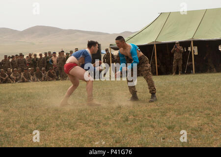 U.S. Marine 1st Lt. Kyle Hardester participates in a traditional Mongolian wrestling match at a Naadam Festival during Khaan Quest 2016 at Five Hills Training Area, Mongolia, June 3. The Naadam Festival featured three sporting events - wrestling, archery and horseback-riding – and is the last official event for participants to experience Mongolian culture prior to the closing ceremony on June 4. Khaan Quest 2016 is an annual, multinational peacekeeping operations exercise hosted by the Mongolian Armed Forces, co-sponsored by U.S. Pacific Command, and supported by U.S. Army Pacific and U.S. Mar Stock Photo