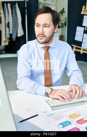 Thoughtful man typing on keyboard Stock Photo
