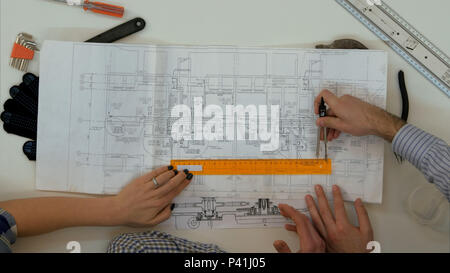 Young architects checking drawing measurements with divider and ruler Stock Photo