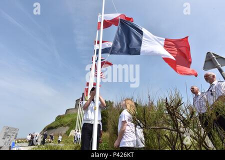PORT EN BESSIN, France (June 06, 2016) International leaders from over 10 countries paid respect to the remembrance of the invasion of Normandy during the 47th Royal Marine Commando Monument Ceremony honoring the sacrifices of World War II veterans. Pictured here, children of France flew flags representing each country involved in the many battles. Each flag was raised while playing the national anthem of each country. A parade field filled with international military formations saluted each flag. (Photo by U.S. Army Sgt. 1st Class Crista Mary Mack/Released) Stock Photo