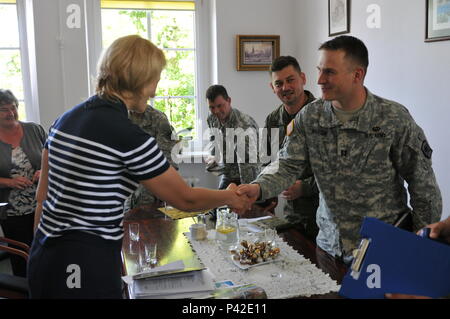 Capt. Niels Madsen and Staff Sgt. Arthur Kleeb of the 457th Civil Affairs Battalion based in Grafenwoehr, Germany; W01 Marcin Cźerwiński,  Maj. Krźysźłof Słrźefecki, and Capt. Hubert Źukowski members of the CIMIC Support Team of the Polish Army discuss concerns with Monika Kuźmińska the mayor of Wegorzyno and other local town officals during Anakonda 2016. Stock Photo