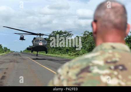 COATEPEQUE, Guatemala – Arkansas National Guard Lt. Col. Darrell Martin, Task Force Red Wolf commander, watches as two New Hampshire National Guard UH-60 Black Hawk utility helicopters prepare to land June 8, 2016, during Exercise BEYOND THE HORIZON 2016 GUATEMALA. Martin awaited the arrival of U.S. Army Brig. Gen. James Wong, deputy commanding general, Director of Operations and National Guard Affairs, U.S. Army South, and Arkansas National Guard Brig. Gen. Keith Klemmer, Assistant to The Adjutant General Support. (U.S. Air Force photo by Senior Airman Dillon Davis/Released) Stock Photo