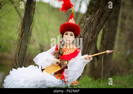 Kazakh people in national costumes. Woman and daughter in the park Stock Photo