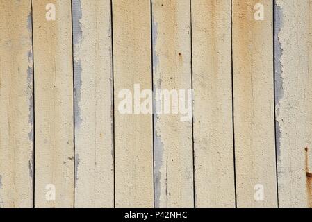 Background: paint peeling from vertical slated wall made of wood in a marine environment Stock Photo